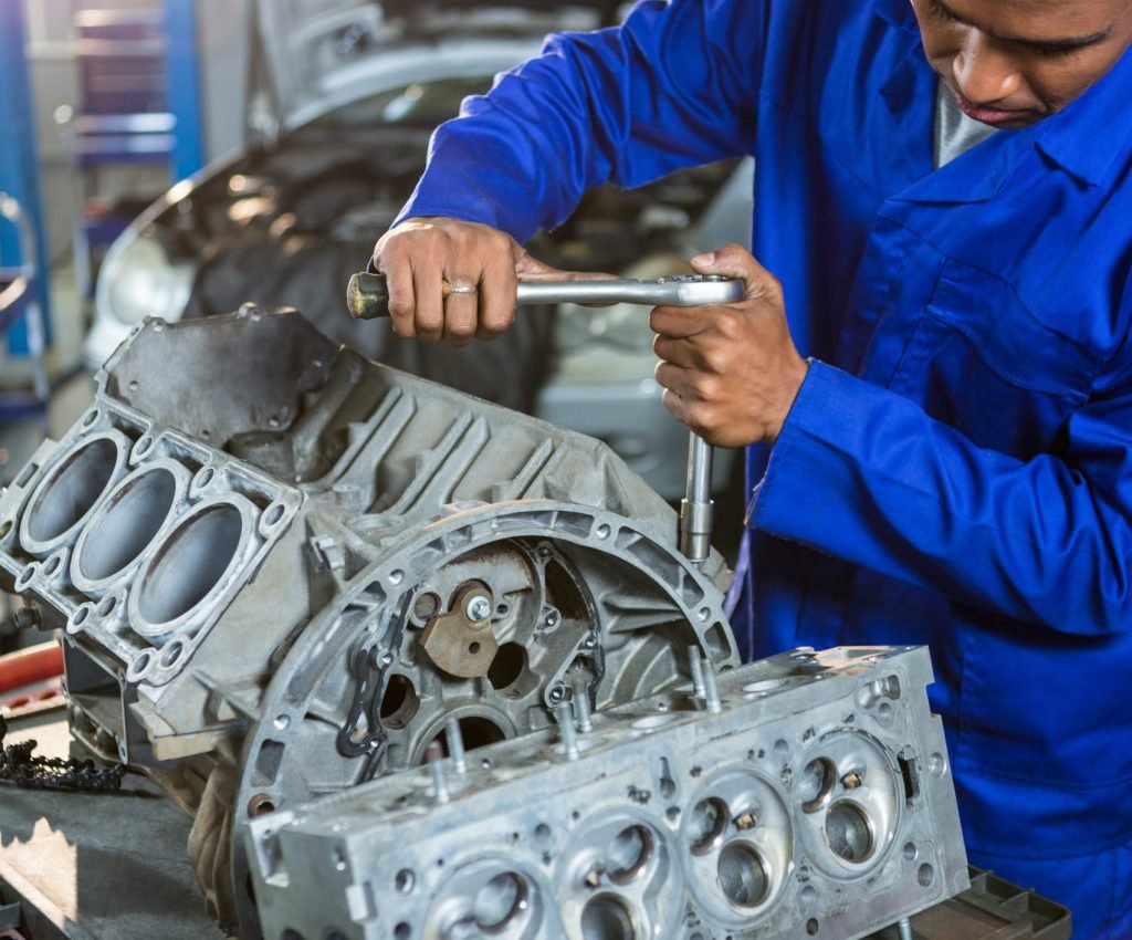 Mechanic repairing engine part with ratchet at the repair garage